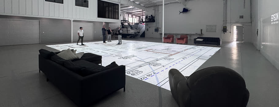 The Cascade studio: a wide, open room with a floor plan projected across the concrete floor and seating arranged at its edge.